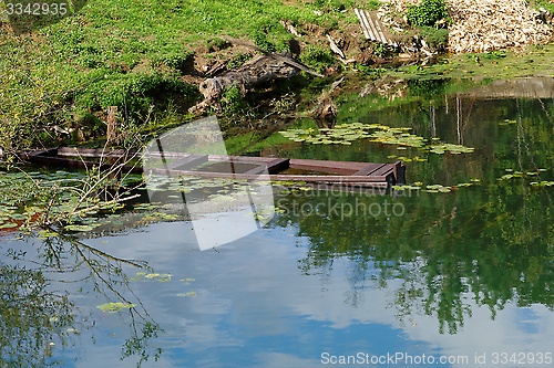 Image of Sunken old wooden boat in summer river