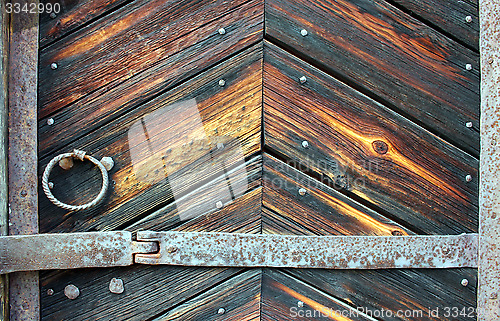 Image of Very old weather beaten door in brownish colours.