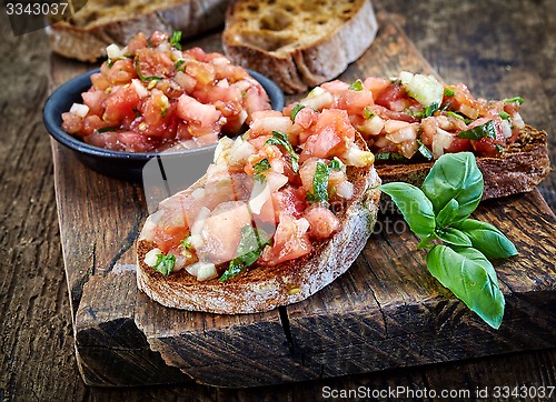 Image of bruschettas ingredients on wooden cutting board