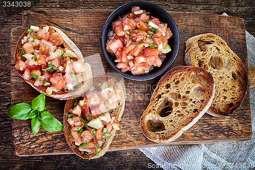 Image of bruschettas ingredients on wooden cutting board