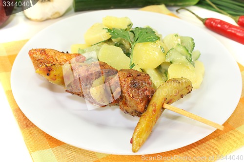 Image of Potato-cucumber salad with fire skewers and parsley