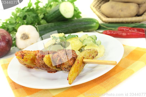 Image of Potato-cucumber salad with fire skewers of pork