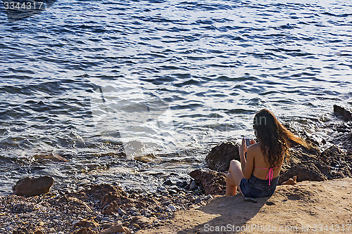 Image of Using mobile smart phone on the coast