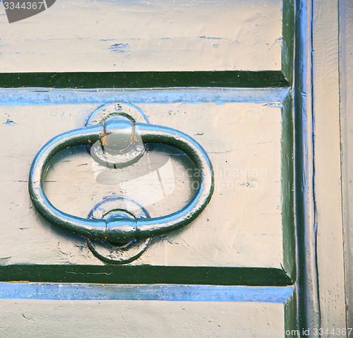 Image of abstract cross   brass brown knocker    closed wood door  tradat