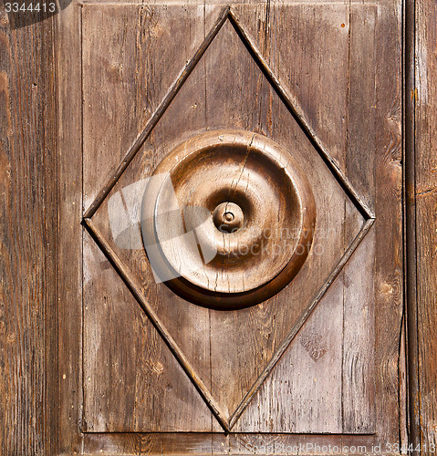 Image of abstract  rusty brass brown knocker in a   closed wood door solb