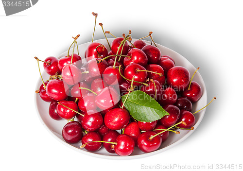 Image of On top sweet cherries with leaf on white plate
