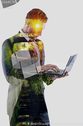 Image of double exposure of business man who working on laptop and alley 