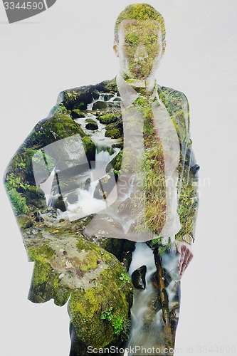 Image of double exposure of business man and creek in forest background