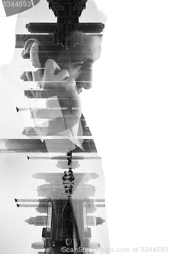 Image of double exposure of business man with  mobile phone and city buil