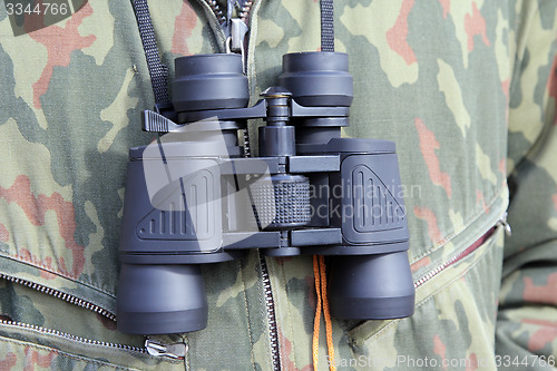 Image of Army and people concept, black binocular hanging on his chest mi