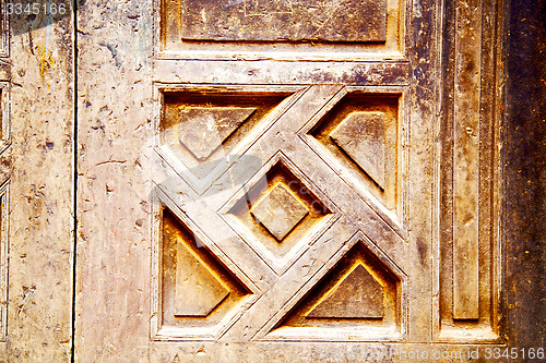 Image of nail dirty stripped paint in the brown wood door and rusty  yell