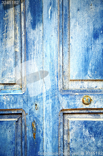 Image of dirty stripped   in the blue wood door  