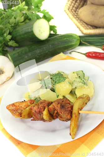 Image of Potato-cucumber salad with fire skewers of pork