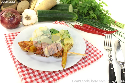 Image of Potato-cucumber salad with fire skewers and parsley