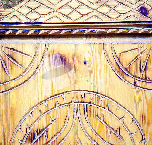 Image of nail dirty stripped paint in the brown wood door and rusty  yell