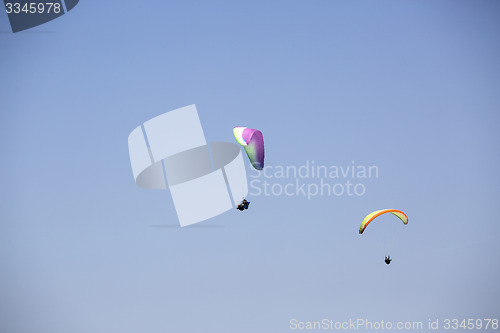 Image of Colorful paragliders with blue sky