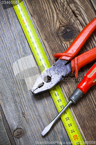 Image of vintage pliers, old screwdriver and measuring tape