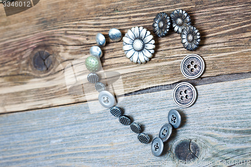 Image of vintage buttons heart on old textured boards