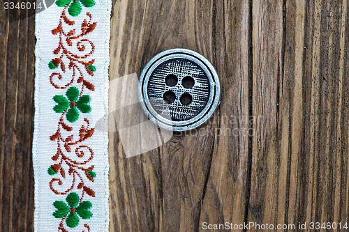 Image of vintage band with embroidered ornaments and old button