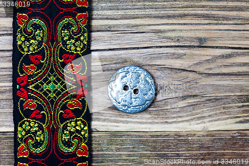 Image of vintage band with embroidered ornaments and old button