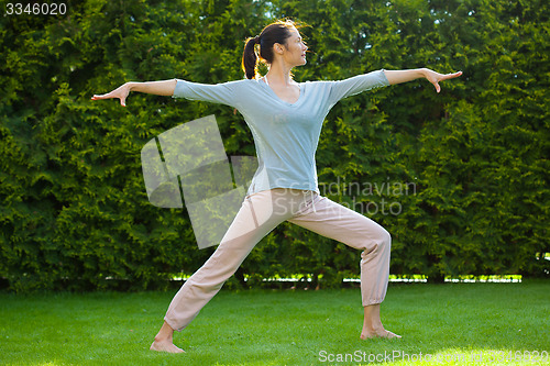 Image of adult pretty woman doing yoga exercises
