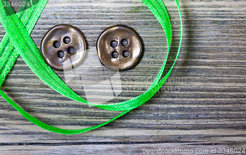 Image of still life with old green tape and two vintage buttons