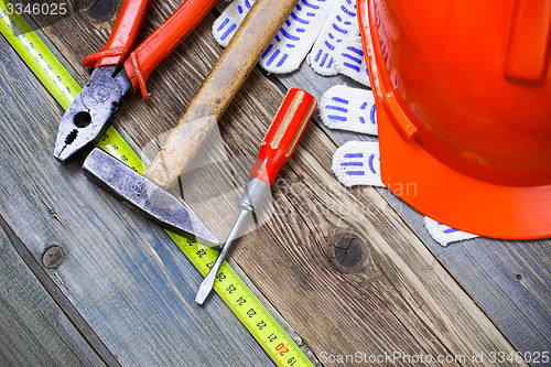 Image of Vintage hammer, pliers, screwdriver, tape measure, a bright helm