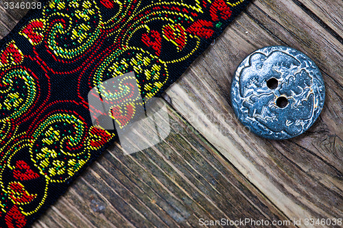 Image of old band with embroidered ornaments and vintage button