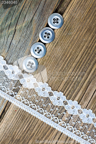 Image of four vintage buttons and lace tape