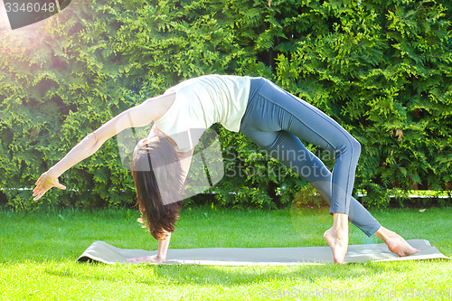 Image of pretty adult woman doing yoga at summer morning