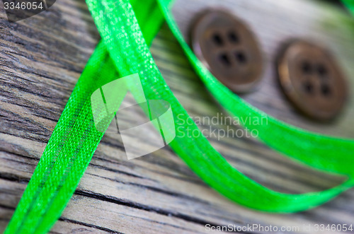 Image of still life with old green tape and two vintage buttons