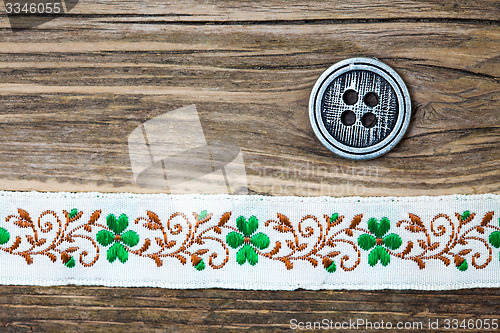 Image of vintage band with embroidered ornaments and old button
