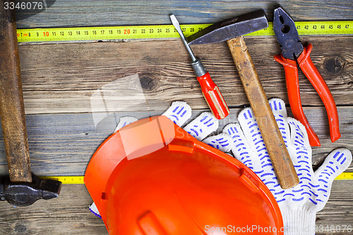 Image of Vintage hammer, pliers, screwdriver, tape measure, a bright helm