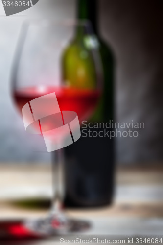Image of red wine in a glass and green bottle