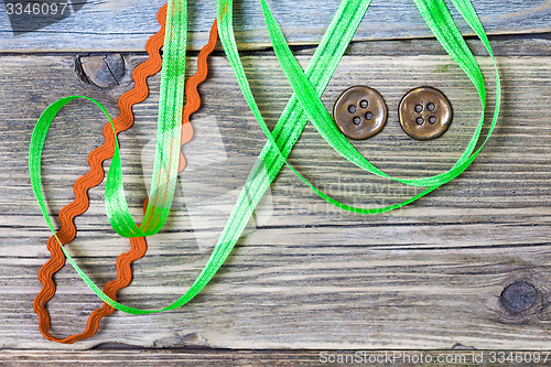 Image of still life with old green and red tapes and two vintage buttons