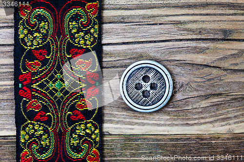 Image of vintage band with embroidered ornaments and old button