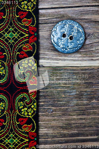 Image of old tape with embroidered ornaments and vintage button