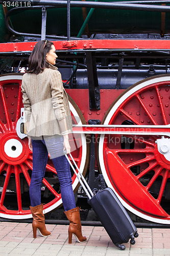 Image of beautiful adult woman traveler with a suitcase