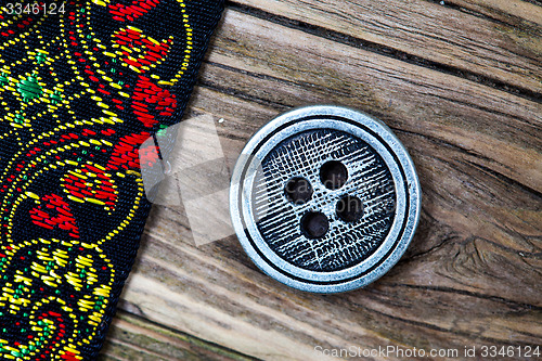 Image of old band with embroidered ornaments and vintage button