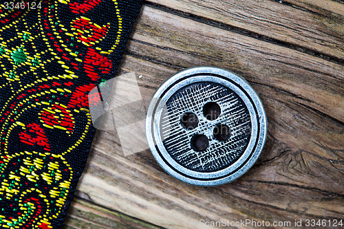 Image of old band with embroidered ornaments and vintage button