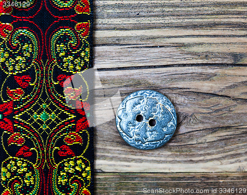 Image of old band with embroidered ornaments and vintage button