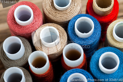 Image of several varicolored spools of thread 