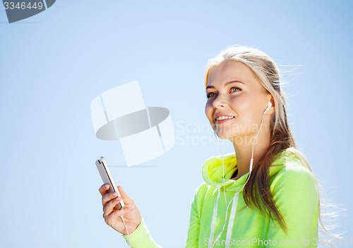 Image of woman listening to music outdoors