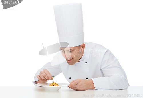 Image of happy male chef cook decorating dish