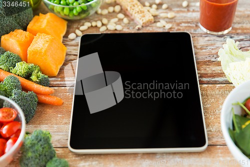 Image of close up of blank tablet pc screen and vegetables