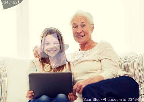 Image of smiling family with tablet pc at home