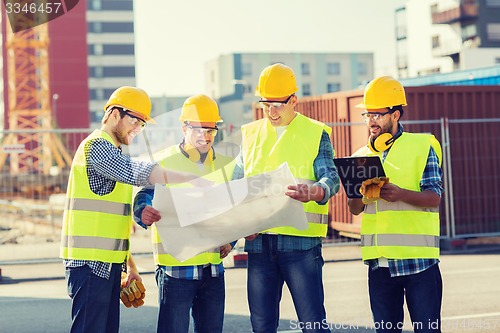 Image of group of builders with tablet pc and blueprint