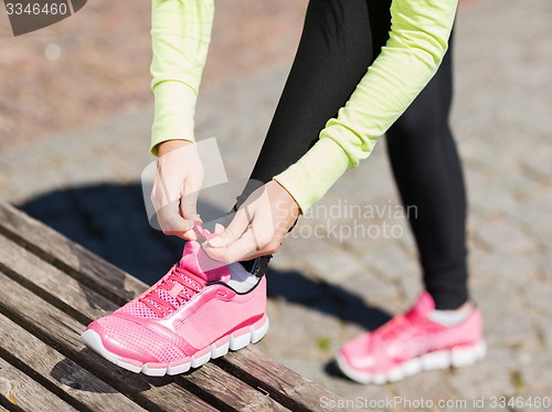 Image of runner woman lacing trainers shoes