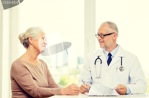 Image of smiling senior woman and doctor meeting