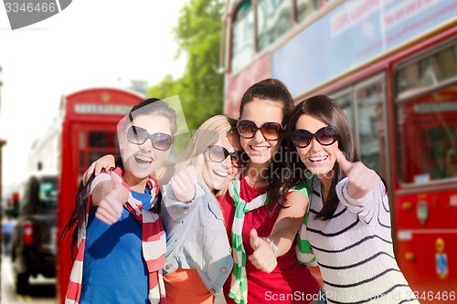 Image of happy teenage girls or women showing thumbs up